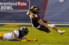 West Virginia cornerback Daryl Porter Jr. sends Minnesota running back Ky Thomas (8) to the turf during the first half of the Guaranteed Rate Bowl NCA