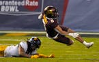 West Virginia cornerback Daryl Porter Jr. sends Minnesota running back Ky Thomas (8) to the turf during the first half of the Guaranteed Rate Bowl NCA