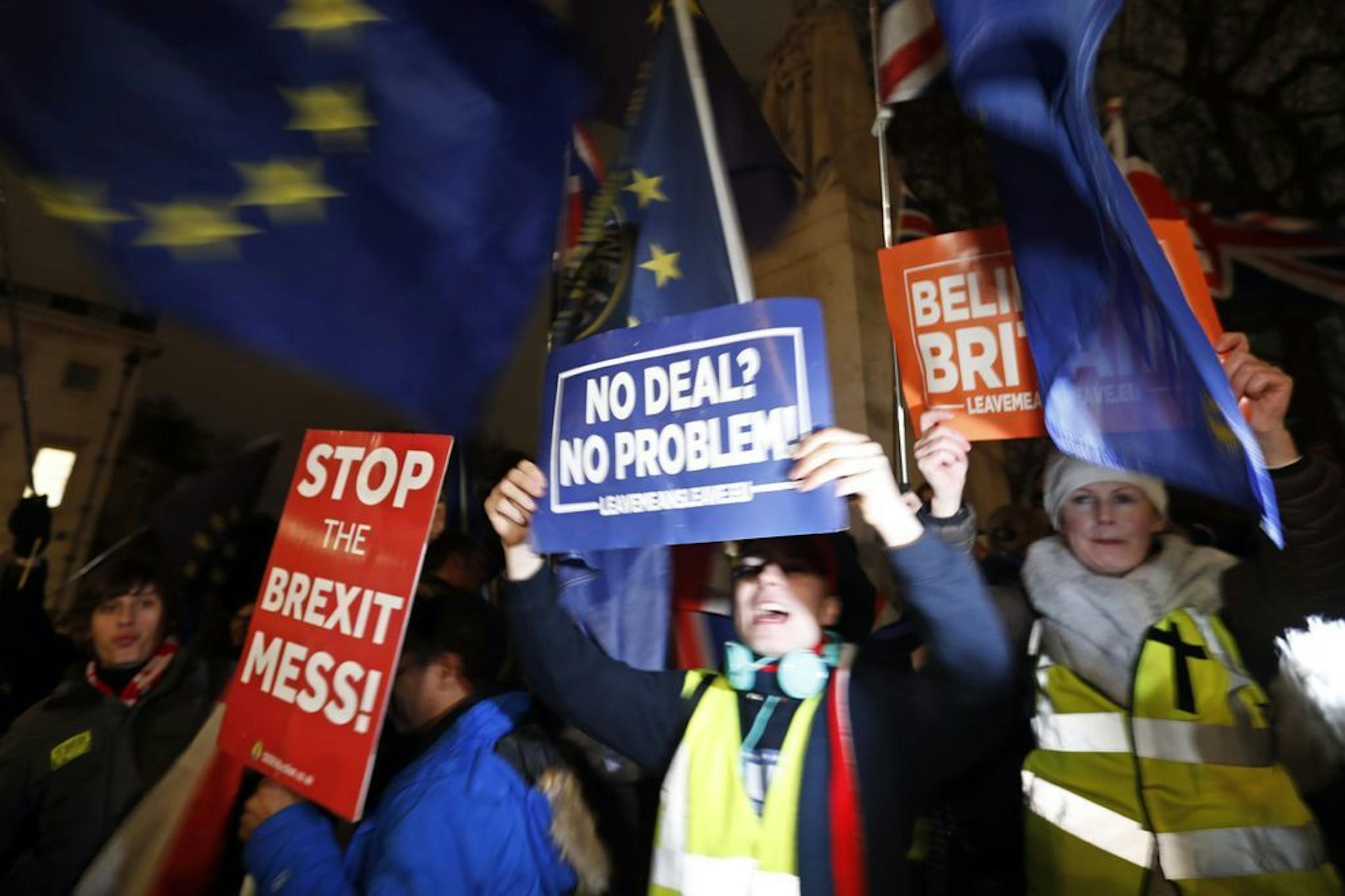Leavers, center right, hold signs next to Pro-European demonstrators at Parliament Square in London, Tuesday, Jan. 15, 2019. Britain's Prime Minister Theresa May is struggling to win support for her Brexit deal in Parliament. Lawmakers are due to vote on the agreement Tuesday, and all signs suggest they will reject it, adding uncertainty to Brexit less than three months before Britain is due to leave the EU on March 29.