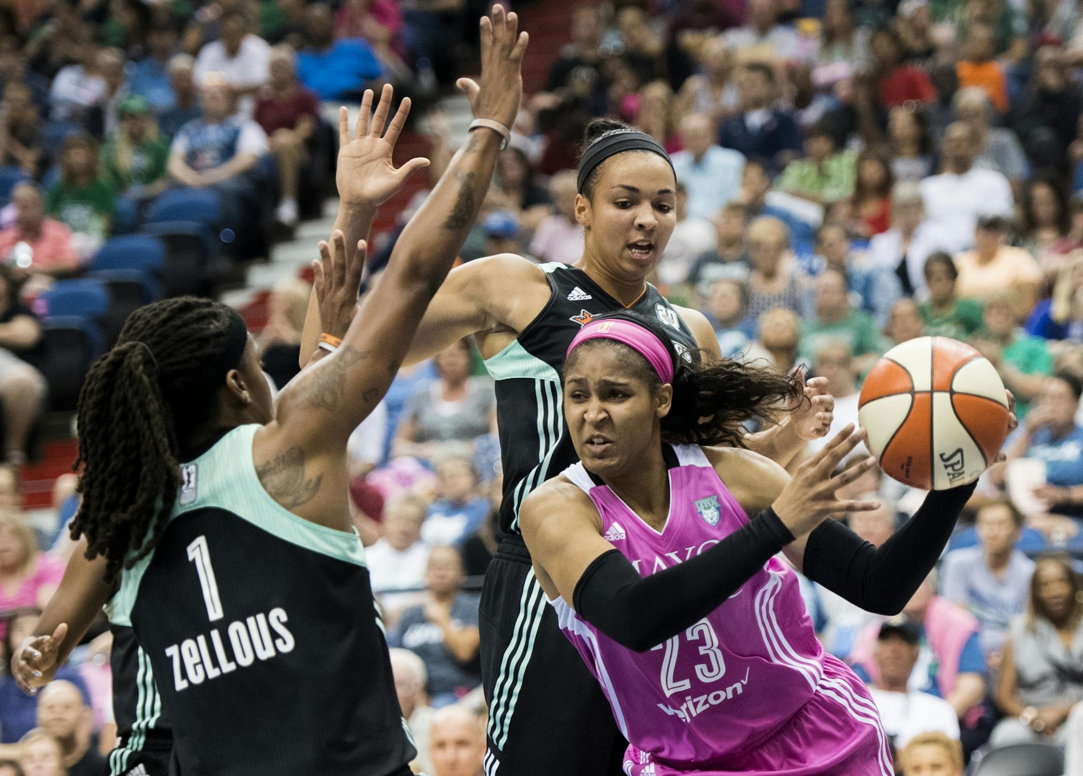 Minnesota Lynx forward Maya Moore (23) drove towards the basket by New York Liberty center Kiah Stokes (41) and guard Shavonte Zellous (1).