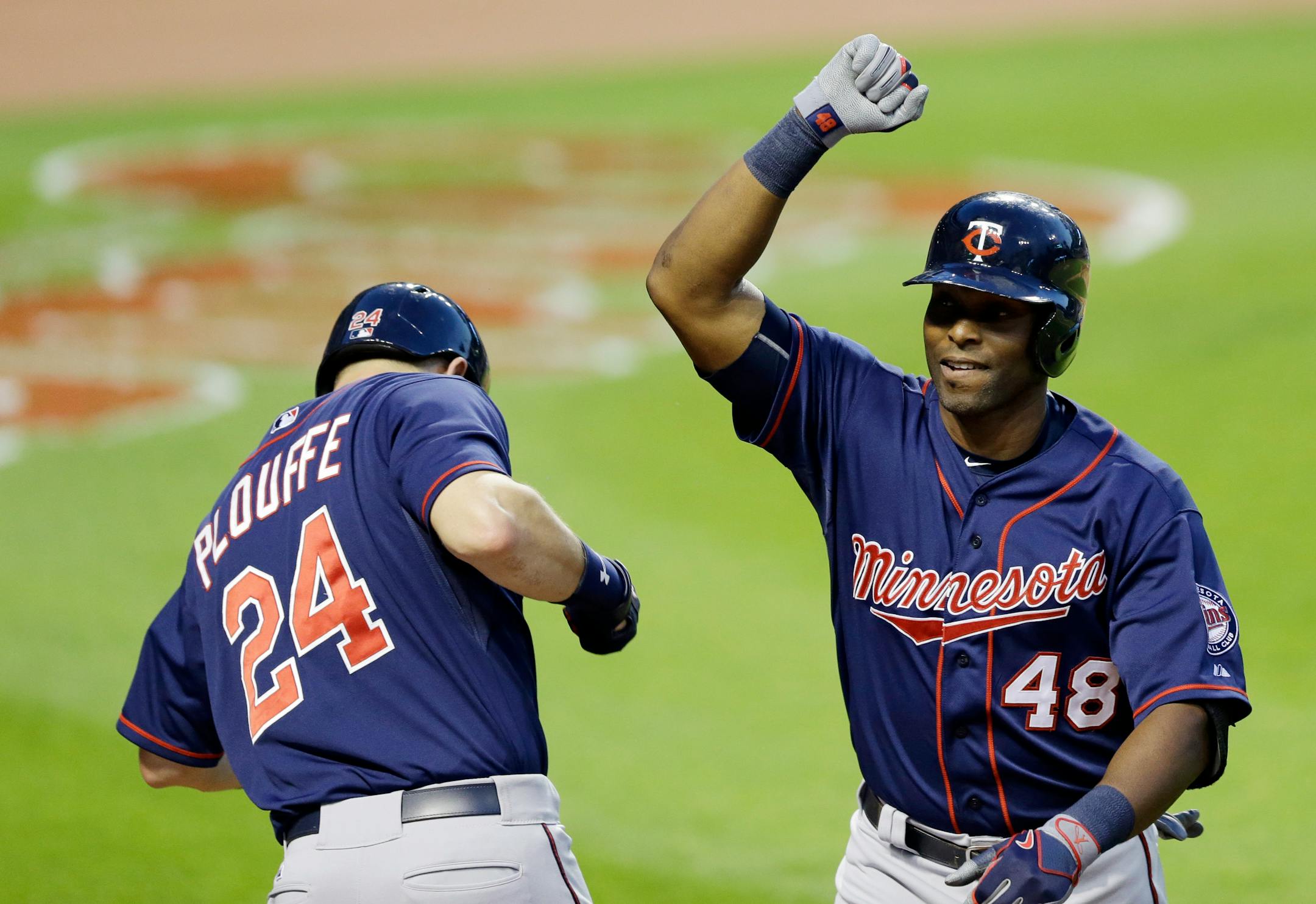 Minnesota Twins' Torii Hunter (48) is congratulated by Trevor Plouffe (24) after Hunter hit a solo home run off Cleveland Indians starting pitcher Trevor Bauer in the fifth inning of a baseball game, Friday, May 8, 2015, in Cleveland. (AP Photo/Tony Dejak)