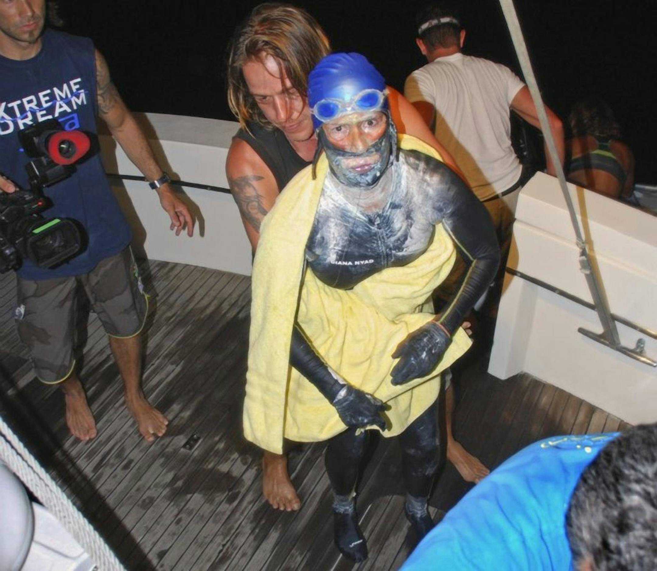 In this photo provided by Diana Nyad via the Florida Keys News Bureau, endurance swimmer Diana Nyad is aided after she was pulled out of the water between Cuba and the Florida Keys early Tuesday, Aug. 21, 2012. Nyad has ended her fourth bid to swim from Cuba to Florida after four days of storms, jellyfish stings and shark threats.