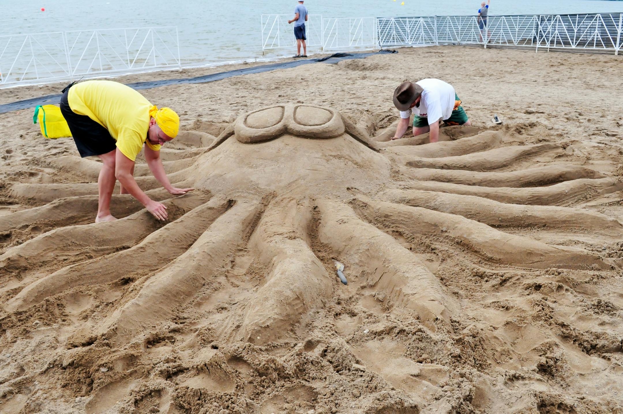 Kendall Bohn, left, and Erik Jorgensen worked on a sun ray sand sculpture at Lake Nokomis.