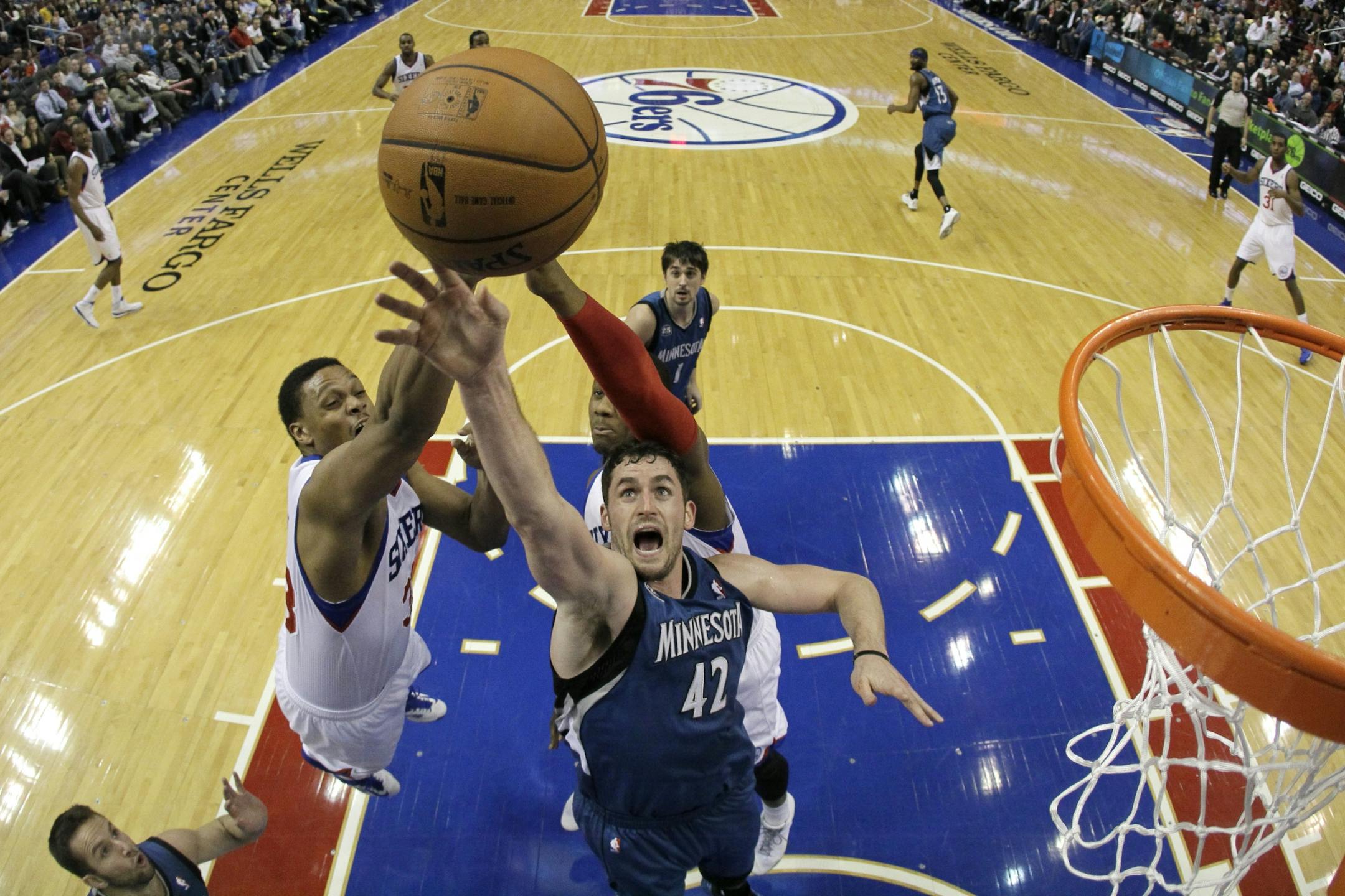 Minnesota Timberwolves' Kevin Love (42) battles for a rebound with Philadelphia 76ers' Daniel Orton, left, and Lavoy Allen during the second half of an NBA basketball game, Monday, Jan. 6, 2014, in Philadelphia. Minnesota won 126-95.