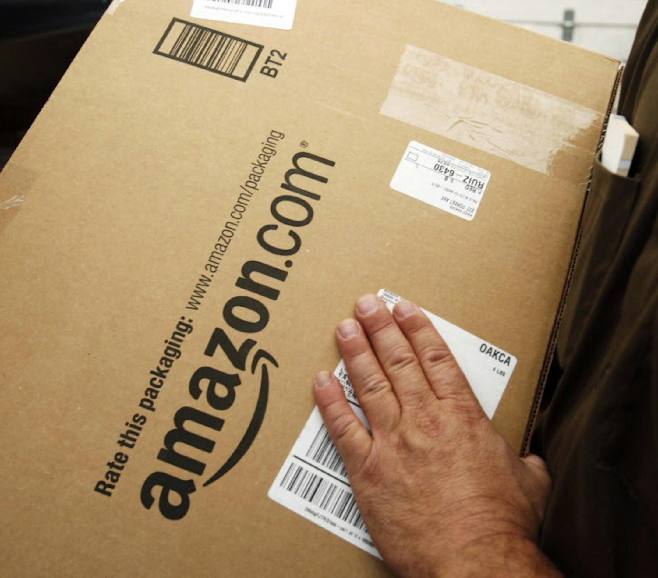 FILE - In this Oct. 18, 2010 file photo, an Amazon.com package is prepared for shipment by a United Parcel Service driver in Palo Alto, Calif. Michigan state legislators in May 2013 are pushing measures to capture the state&#xed;s share of hundreds of millions of dollars in annual taxes from Amazon, eBay and other Internet retailers. Under bipartisan bills being debated in the state House, Internet retailers would have to charge sales tax if they have distribution centers or warehouses in Michig