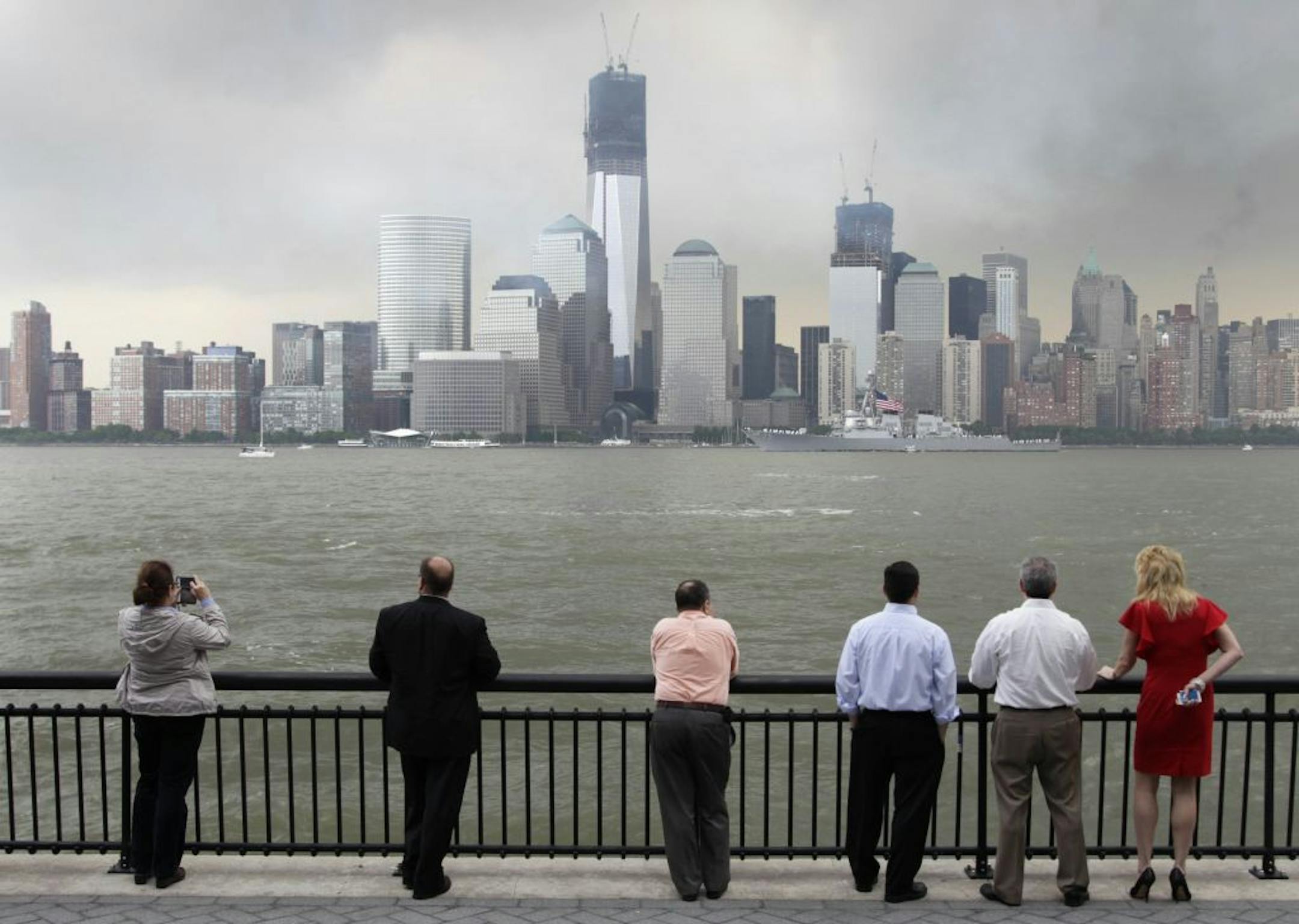 People watch the USS Donald Cook pass lower Manhattan and the World Trade Center site from Jersey City, N.J., Wednesday, May 23, 2012. Naval vessels ranging from a U.S. amphibious assault ship to a Finnish minelayer are participating in New York City's Fleet Week.