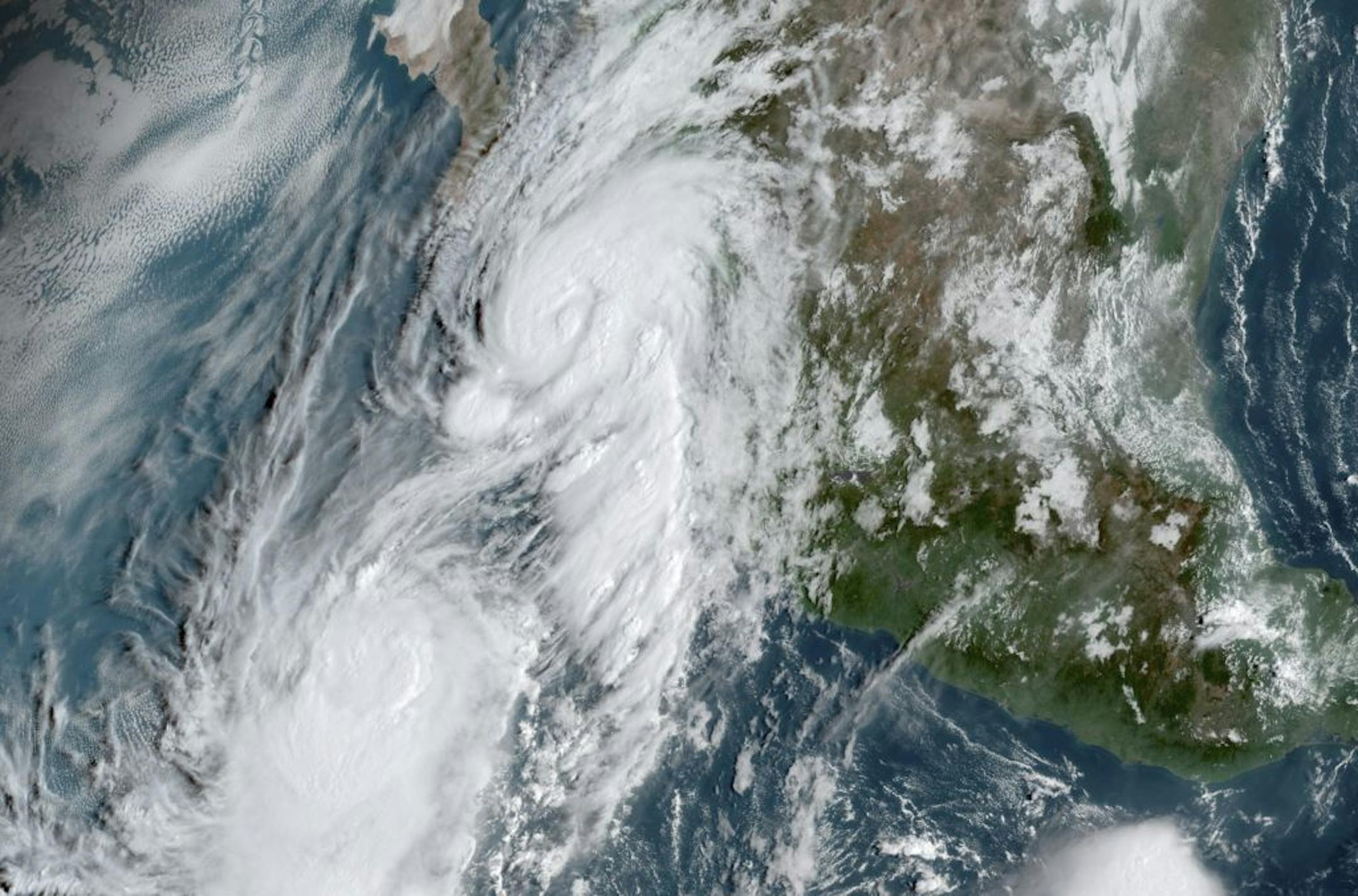 This GOES-16, GeoColor satellite image taken Friday, Sept. 20, 2019, at 14:50 UTC and provided by National Oceanic and Atmospheric Administration (NOAA), shows Hurricane Lorena, top center, followed by Tropical Storm Mario, near the southern tip of Mexico's Baja California peninsula.