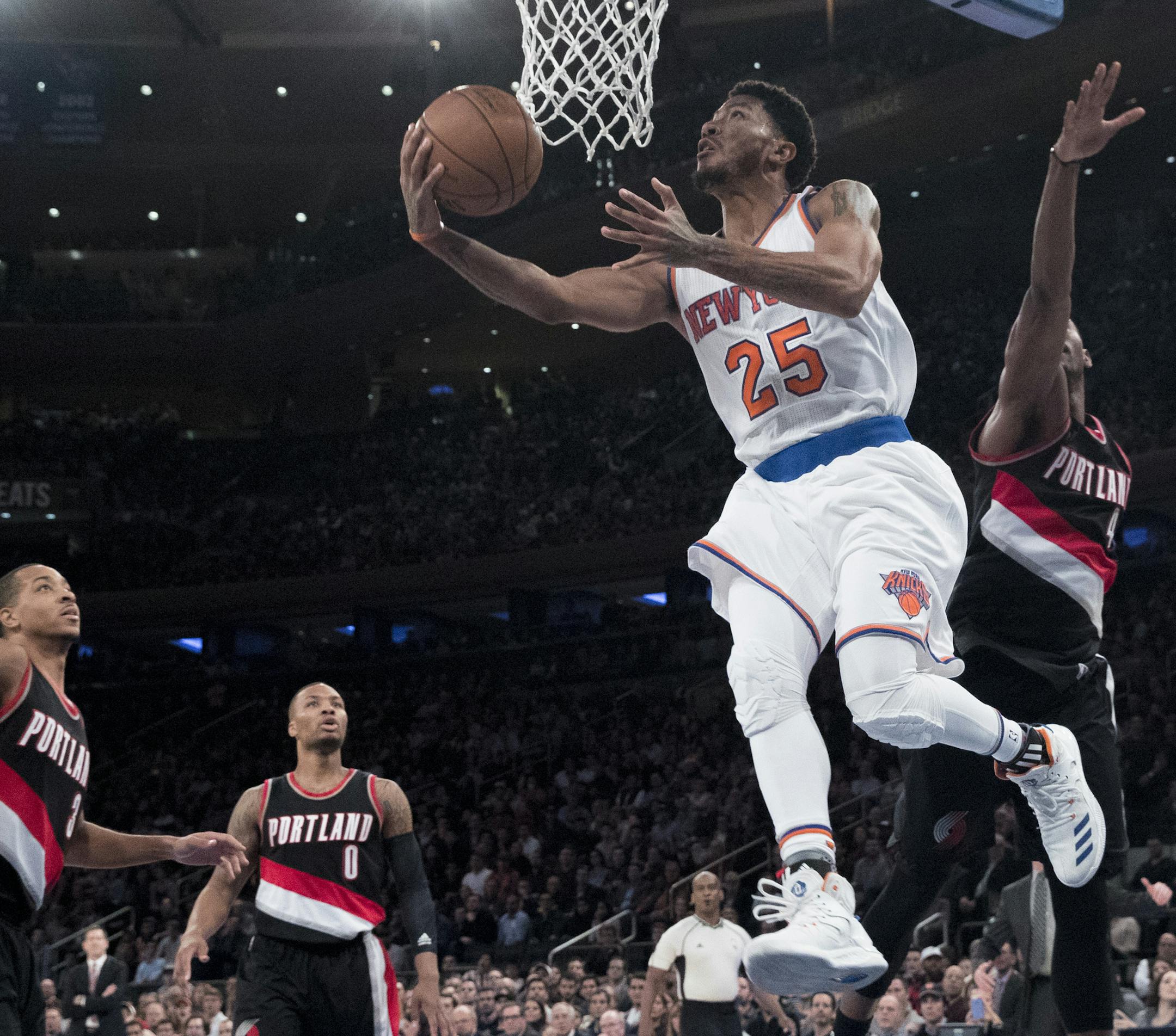New York Knicks guard Derrick Rose (25) goes to the basket past Portland Trail Blazers guard C.J. McCollum (3), guard Damian Lillard (0) and forward Maurice Harkless (4) during the second half of an NBA basketball game, Tuesday, Nov. 22, 2016, at Madison Square Garden in New York. The Knicks won 107-103. (AP Photo/Mary Altaffer)