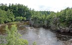The St. Croix River cuts through a basalt gorge known as the Dalles of the St. Croix in St. Croix Falls. The dramatic rock walls are part of Interstat