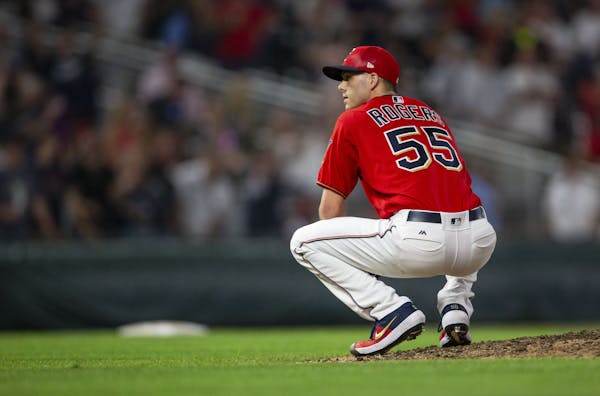 Minnesota Twins relief pitcher Taylor Rogers (55) crouches in disbelief after he believed he had thrown the game winning strike that was called a ball