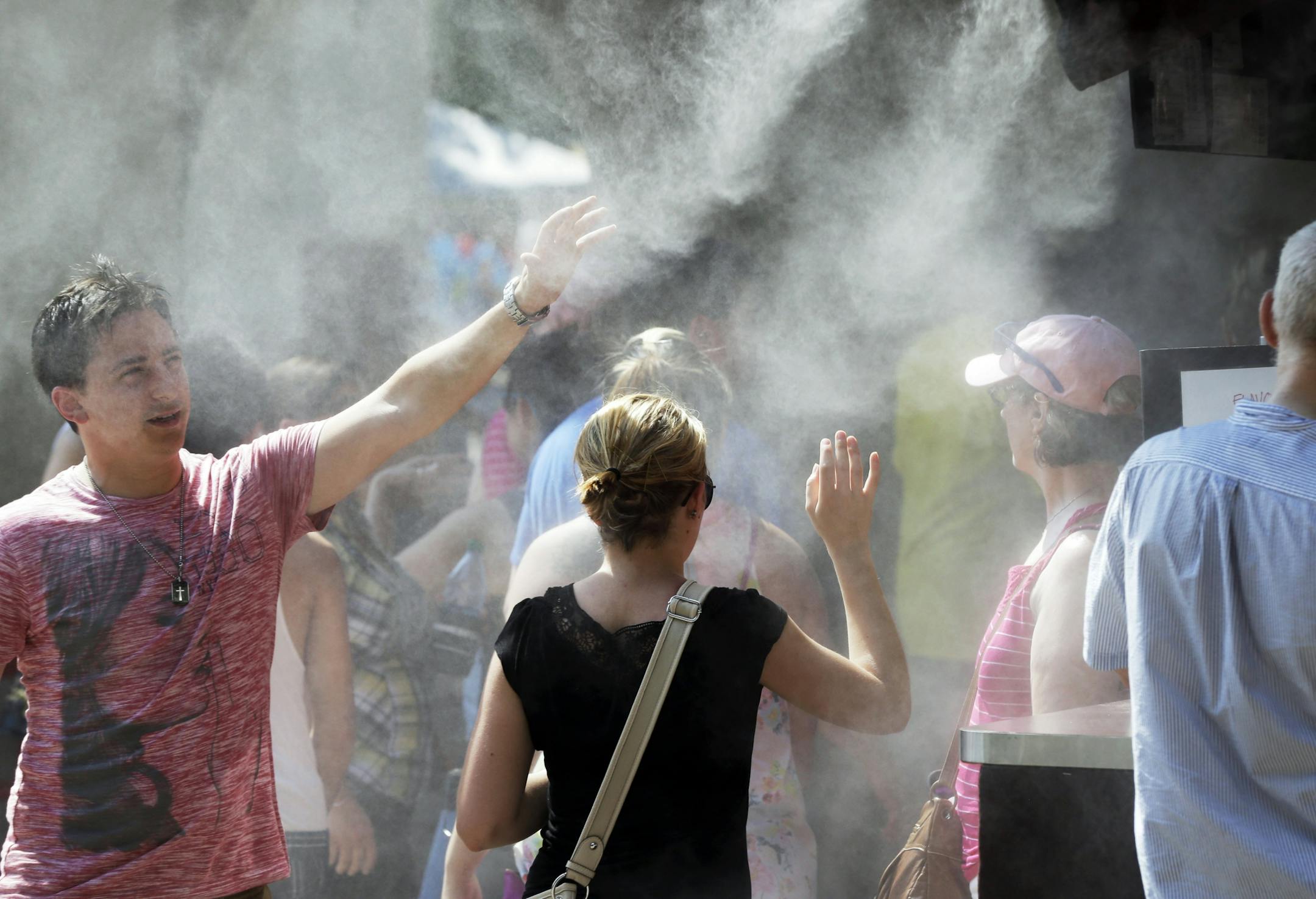 With temperatures in the 90's and high humidity, Minnesota State Fair goers took advantage of cool water mist at a coffee concession on Monday.