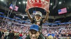 Andre Springer with son Michael,3, held up their sign for Trump. President Trump claimed a record crowd for Target Center.] President Donald Trump add