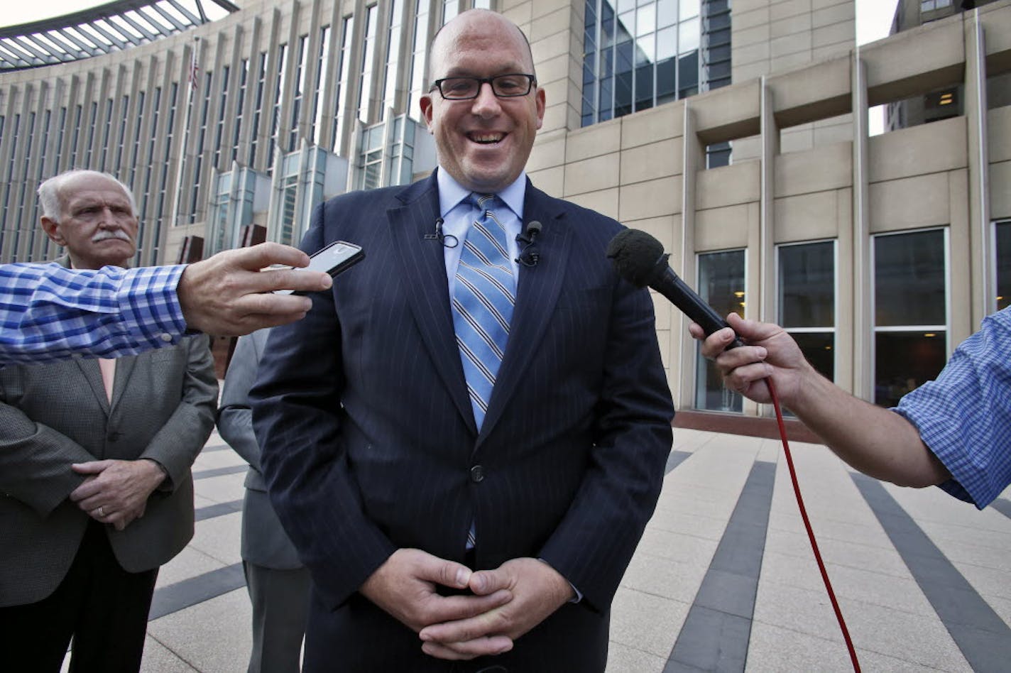 Michael Brodkorb, along with his father, Bernie, left, held a press conference outside the Federal Courthouse in Minneapolis on Thursday to announce the settlement of his lawsuit against the Minnesota Senate.