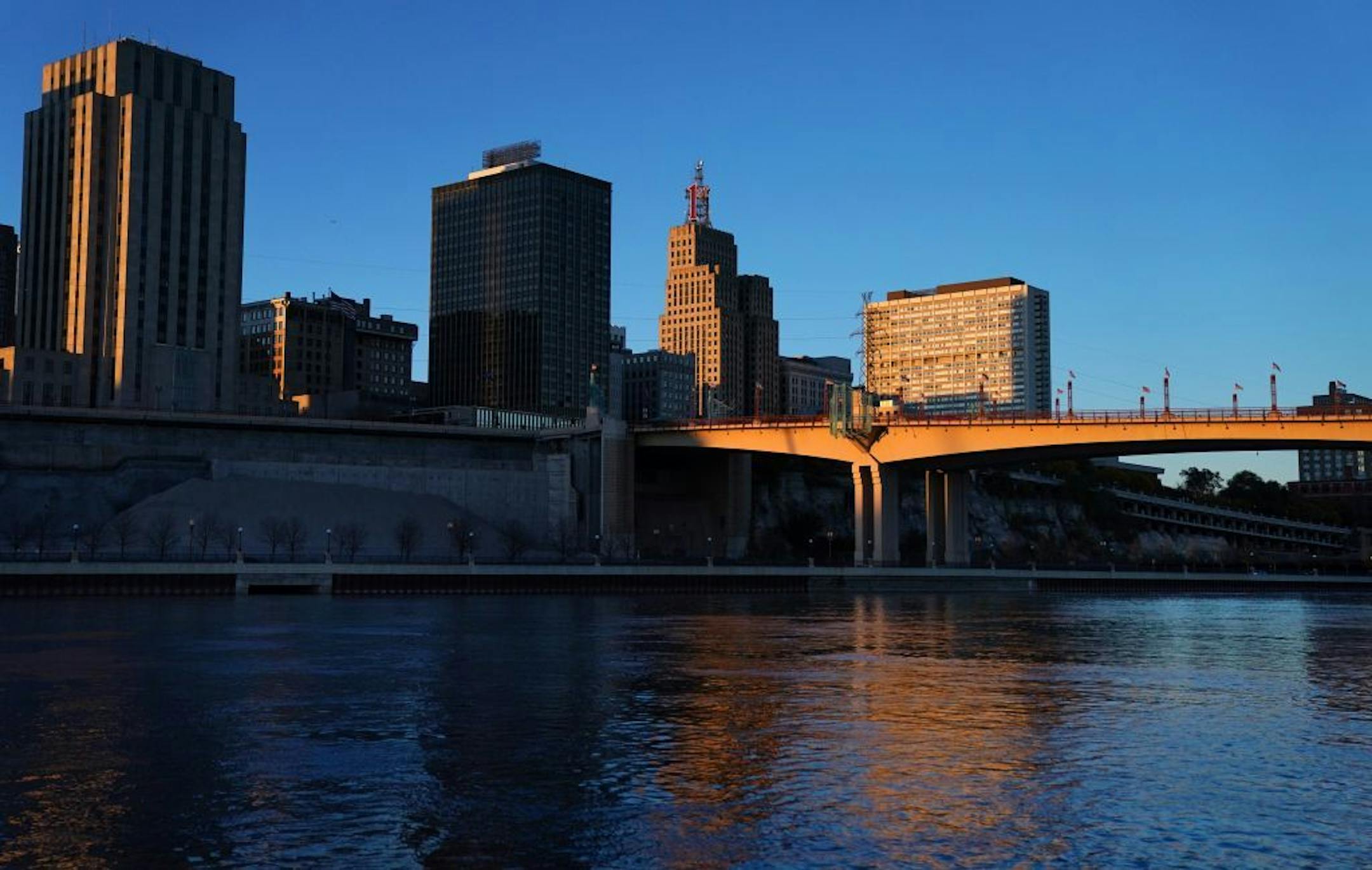 The setting sun illuminated the St. Paul skyline, with city hall on the left, as seen from Harriet Island Park.