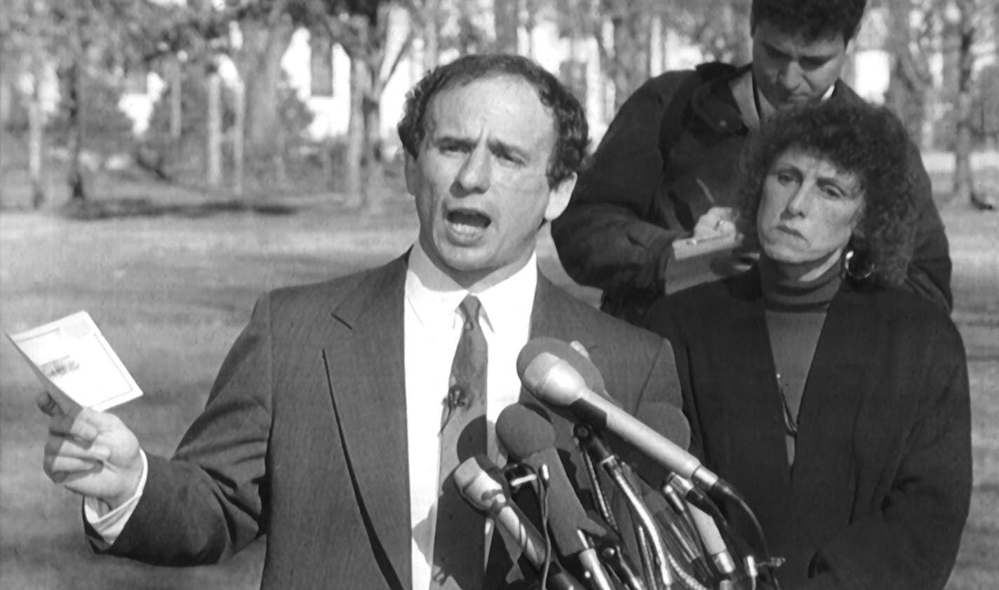 Minnesota's US Senator-elect Paul Wellstone (left), with wife Sheila (right), holds a news conference in front of the Vietnam Veteran's Memorial in Washington DC, Jan 2, 1991, about US involvement in the Persian Gulf. The Wellstones had stopped to make a rubbing of the name of Bill Deetz, from Northfield MN. Sheila Wellstone also laid a bouquet of roses by the wall. Photo by Associated Press staff photographer Dennis Cook.