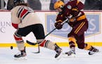 Gophers forward Amy Potomak took a shot as Ohio State defenseman Madison Bizal tried to block it during Minnesota's 2-1 victory in an outdoors game at