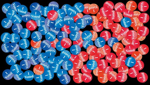 Several red and blue "I voted" stickers across a black background. The blue stickers are on the left and the red stickers are on the right