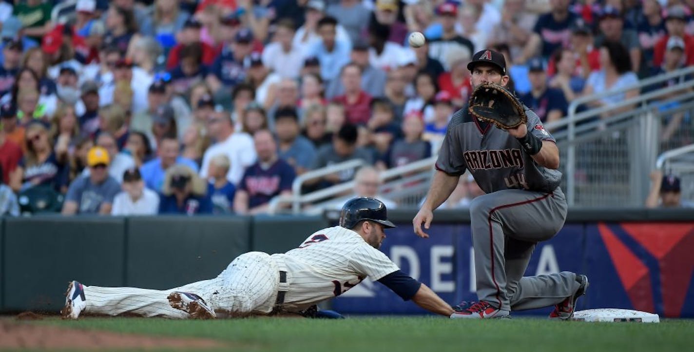 Minnesota Twins second baseman Brian Dozier (2) slid safely back to first to beat the tag by Arizona Diamondbacks first baseman Paul Goldschmidt (44) in the bottom of the first inning.