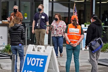 Following the first day of early voting morning rush, poll workers stood outside waiting for more voters at Minneapolis Elections and Voter Services S