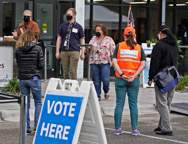 Following the first day of early voting morning rush, poll workers stood outside waiting for more voters at Minneapolis Elections and Voter Services S