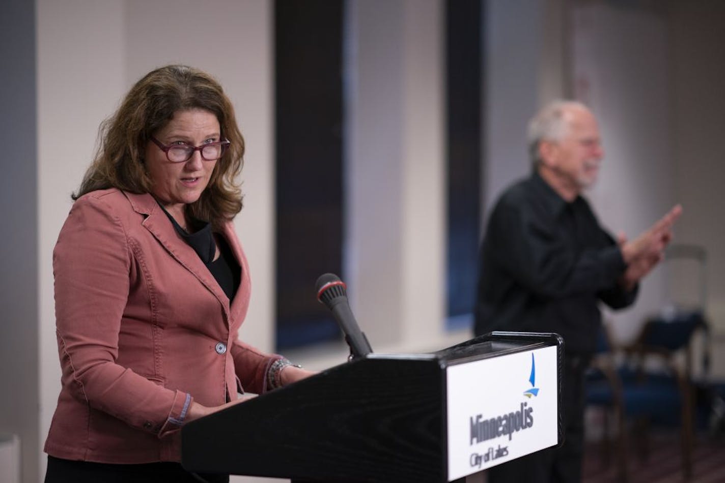 Andrea Brennan, Director of Housing Policy and Development for the City of Minneapolis, spoke at the briefing while sign language interpreter Albert Walla worked at right.