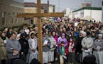 Pro-life supporters stood in front of cross as they protested outside Planned Parenthood on good Friday in St. Paul, Minn., on April 14, 2017. In the 