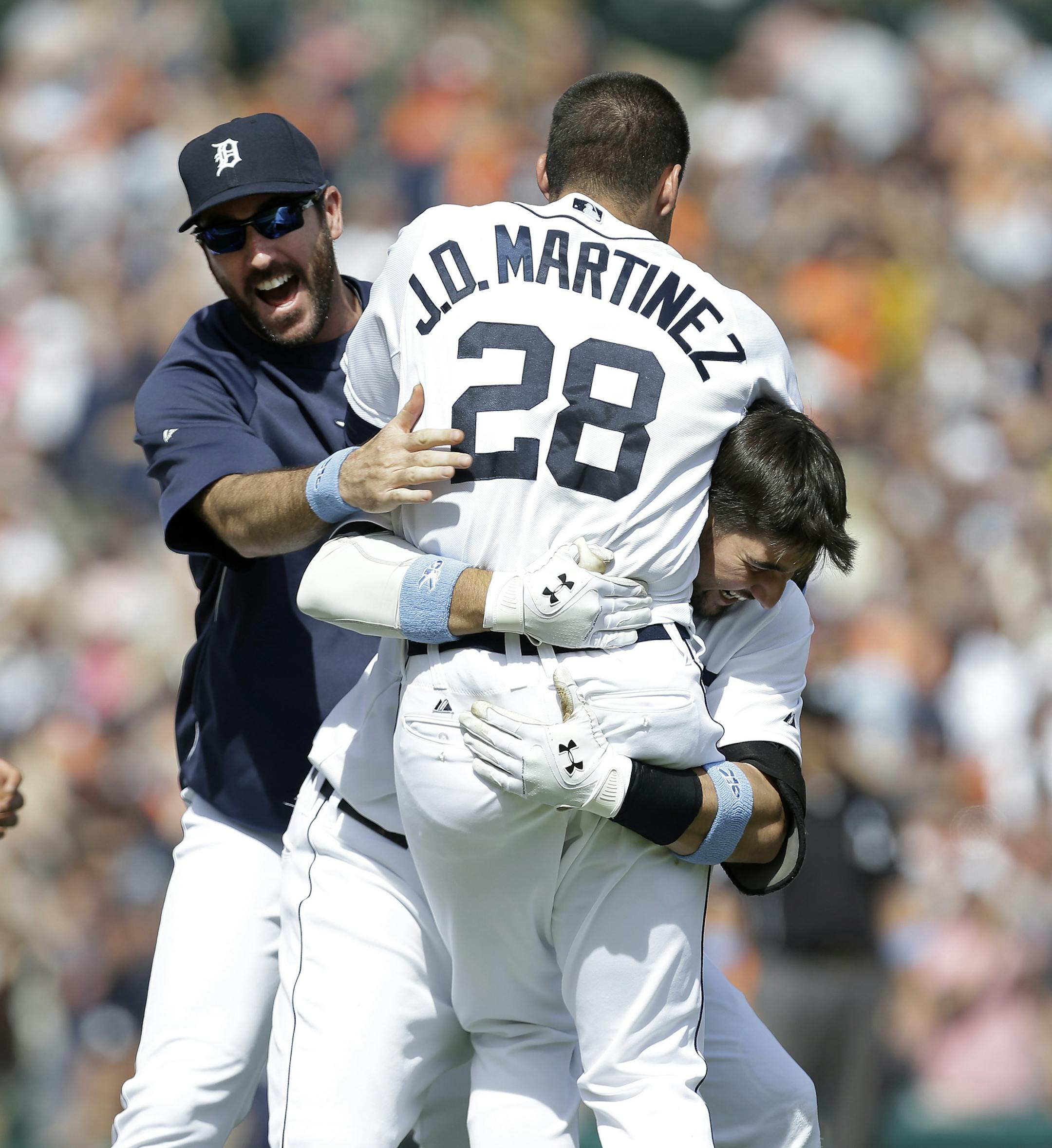 Detroit Tigers' J.D. Martinez (28) celebrates with Nick Castellanos, right, and pitcher Justin Verlander after hitting a walkoff sacrifice fly scoring Torii Hunter against the Minnesota Twins in the ninth inning of a baseball game in Detroit, Sunday, June 15, 2014. Detroit won 4-3. (AP Photo/Paul Sancya)