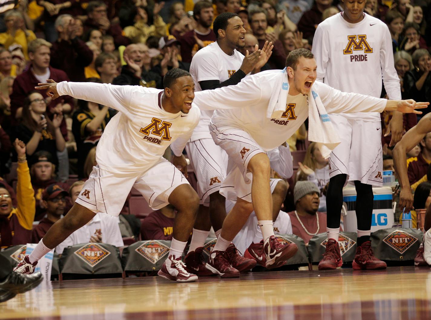 Minnesota's Kendal Shell, left, Oto Osenieks, right, and Malik Smith, back, celebrate after teammate Deandre Mathieu hit a three-point basket during the second half of an NIT tournament second-round basketball game, Sunday, March 23, 2014, in Minneapolis. Minnesota won 63-55. (AP Photo/Paul Battaglia)