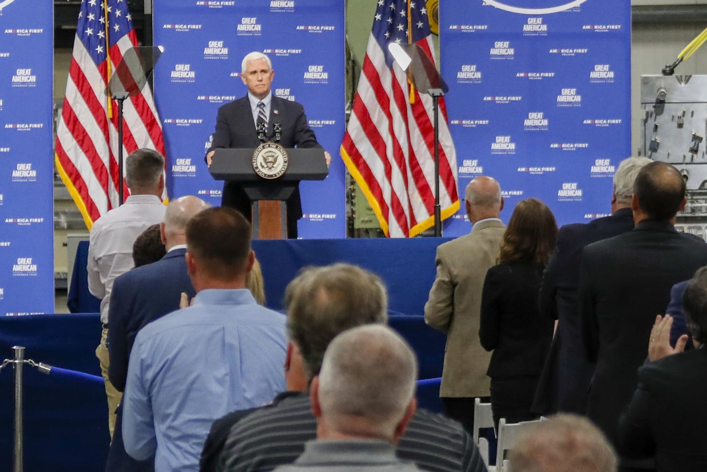 People stand and applaud after Vice President Mike Pence said he would not defund the police during an address after a tour at Oberg Industries plant in Sarver, Pa. Friday, June 12, 2020, (AP Photo/Keith Srakocic)