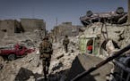 FILE -- Iraqi special forces soldiers search houses for explosives and any remaining Islamic State fighters in a destroyed section of the Old City of 