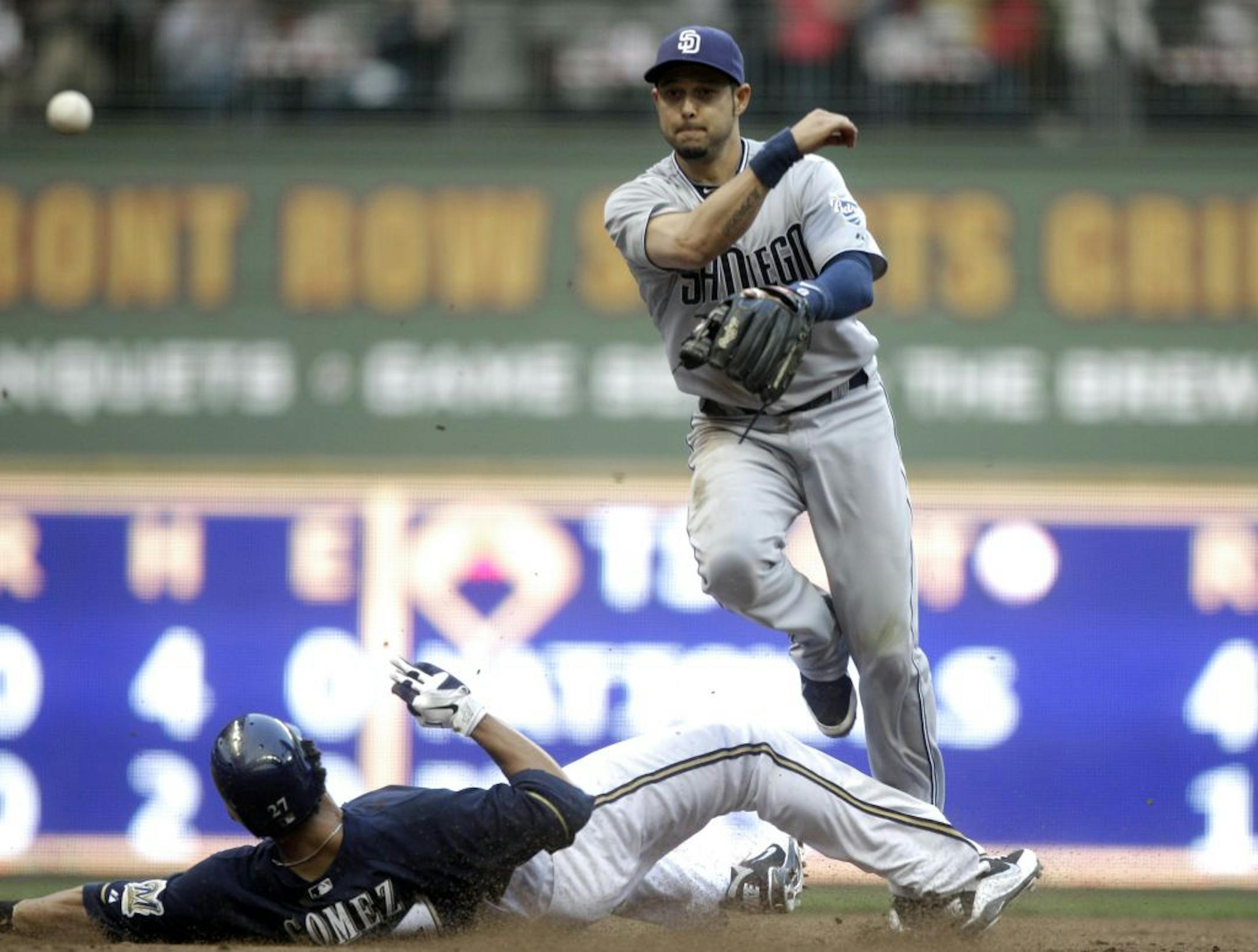 San Diego Padres shortstop Jason Bartlett, right, throws to first to complete a double play as Carlos Gomez tries to take him out.