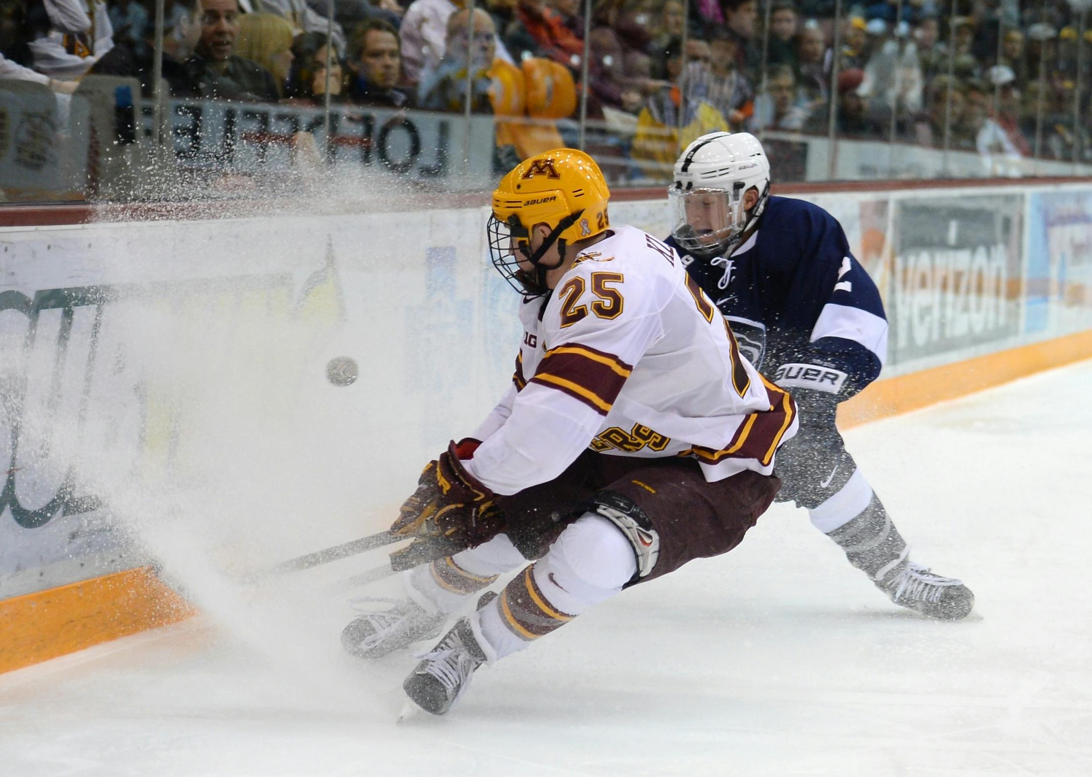 Minnesota Golden Gophers center Justin Kloos (25) tried to control the puck while being defended by Penn State Nittany Lions defenseman Connor Varley (2) in the second period.
