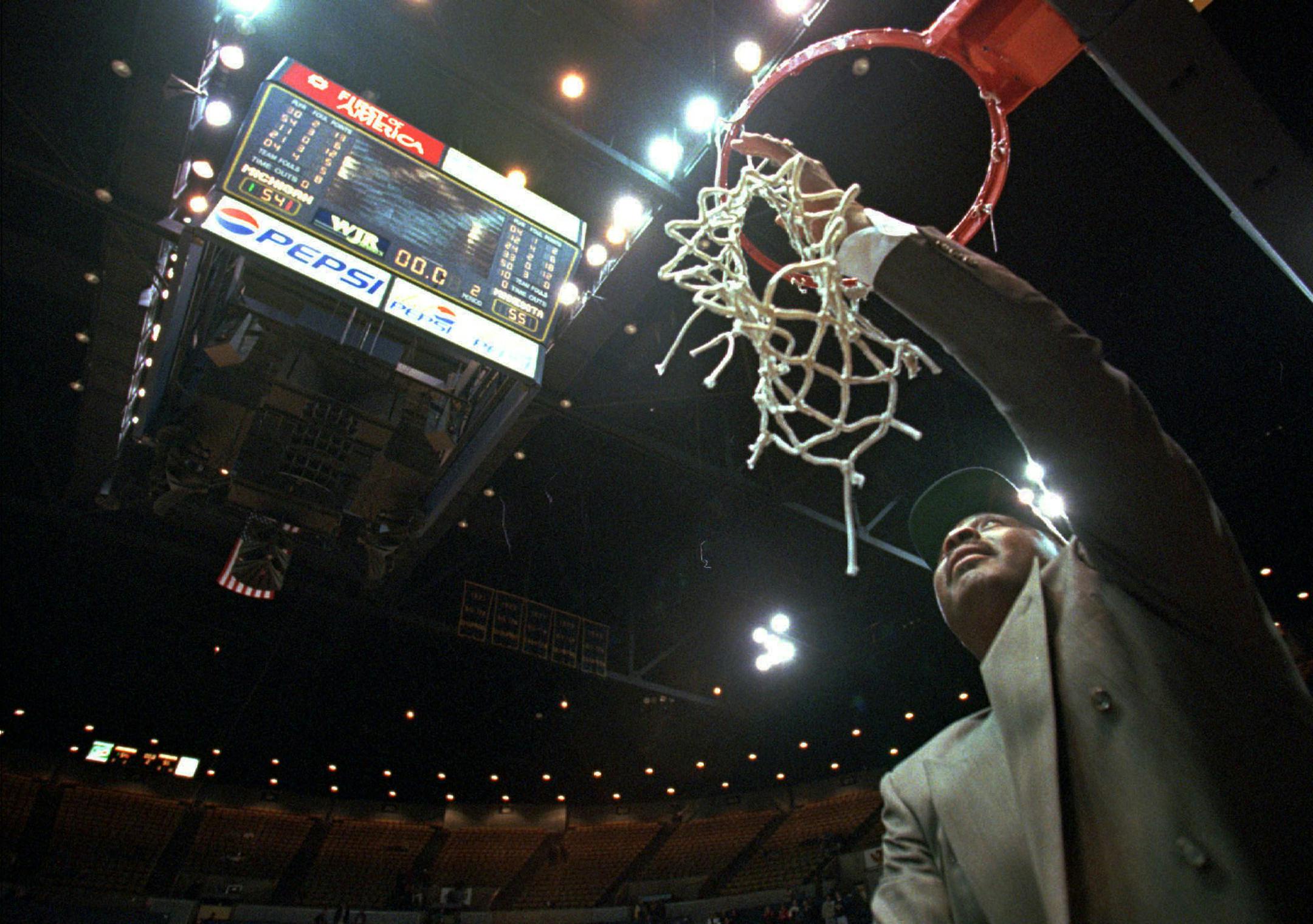 Minnesota coach Clem Haskins cuts down the victory net after Minnesota defeated Michigan 55-54 at Crisler Arena in Ann Arbor, Mich., on Wednesday, Feb. 26, 1997. Second-ranked Minnesota clinched the Big Ten championship with its win over Michigan. (AP Photo/Tom Pidgeon)