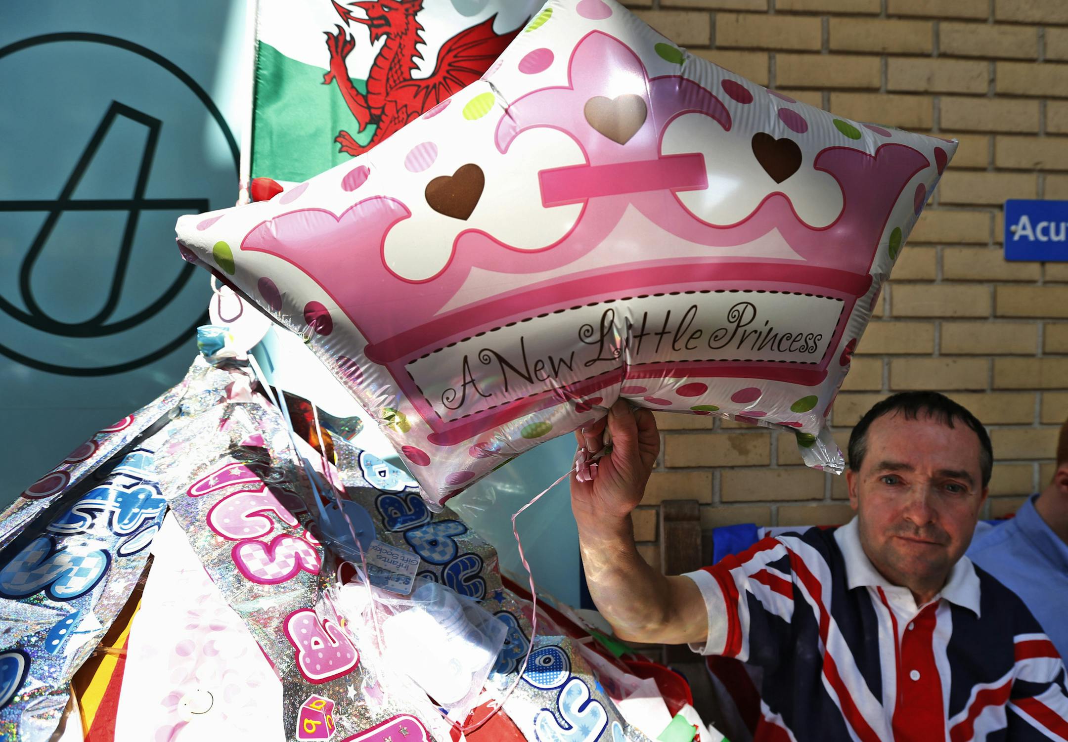 Royal supporter John Loughrey poses with his royal baby memorabilia as he waits across the street from St. Mary's Hospital exclusive Lindo Wing in London, Wednesday, July 17, 2013. Media are preparing for royal-mania as Britain's Duchess of Cambridge plans to give birth to the new third-in-line to the throne in mid-July, at the Lindo Wing. Cameras from all over the world are set to be jostling outside for an exclusive first glimpse of Britain's Prince William and the Duchess of Cambridge's first