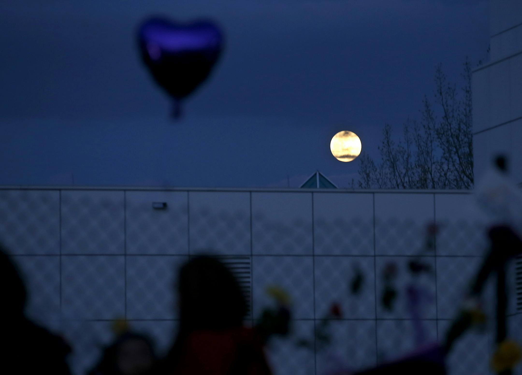The moon appeared to rise behind a balloon and well wishers at a memorial at Paisley Park Studios in Chanhassen, MN. Musician Prince was found dead at the site on Thursday morning.