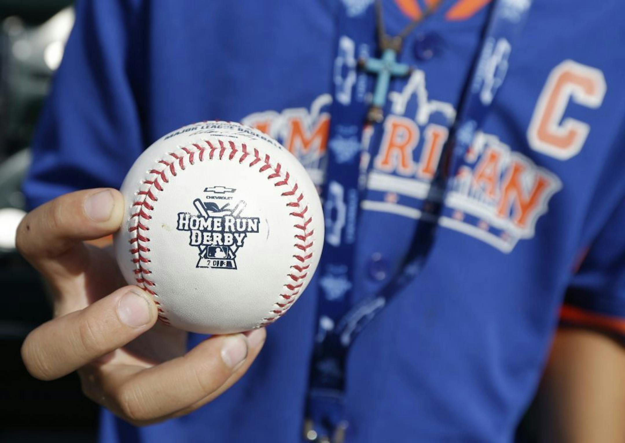 Twelve-year-old Phoenix Leyritz holds a Home Run Derby baseball before the MLB All-Star baseball game, on Tuesday, July 16, 2013, in New York.