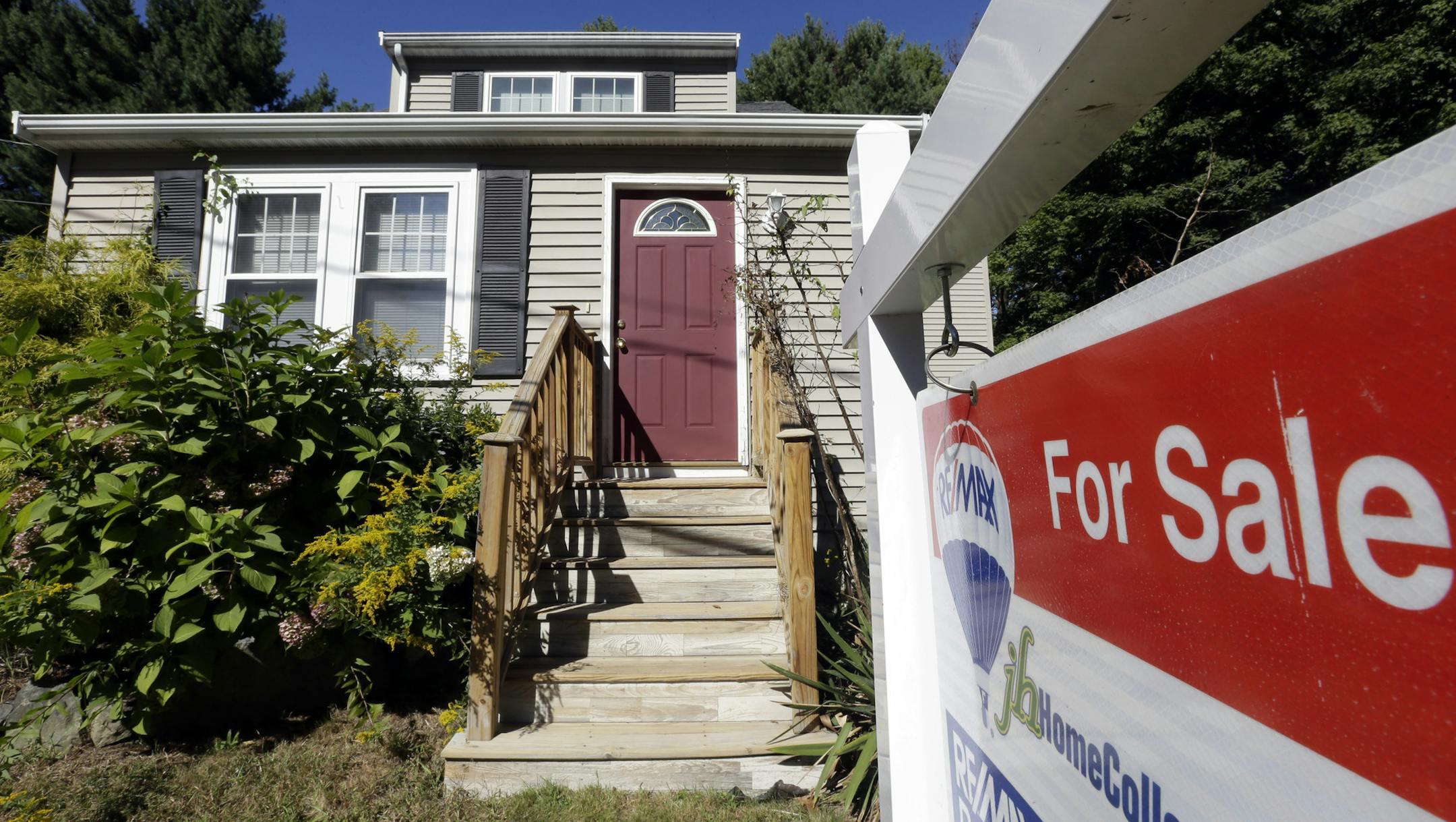 In this Wednesday, Sept. 18, 2013 photo a for sale sign hangs in front of a house in Walpole, Mass. Freddie Mac reports on mortgage rates for the last week of September on, Thursday, Oct. 3, 2013. (AP Photo/Steven Senne)