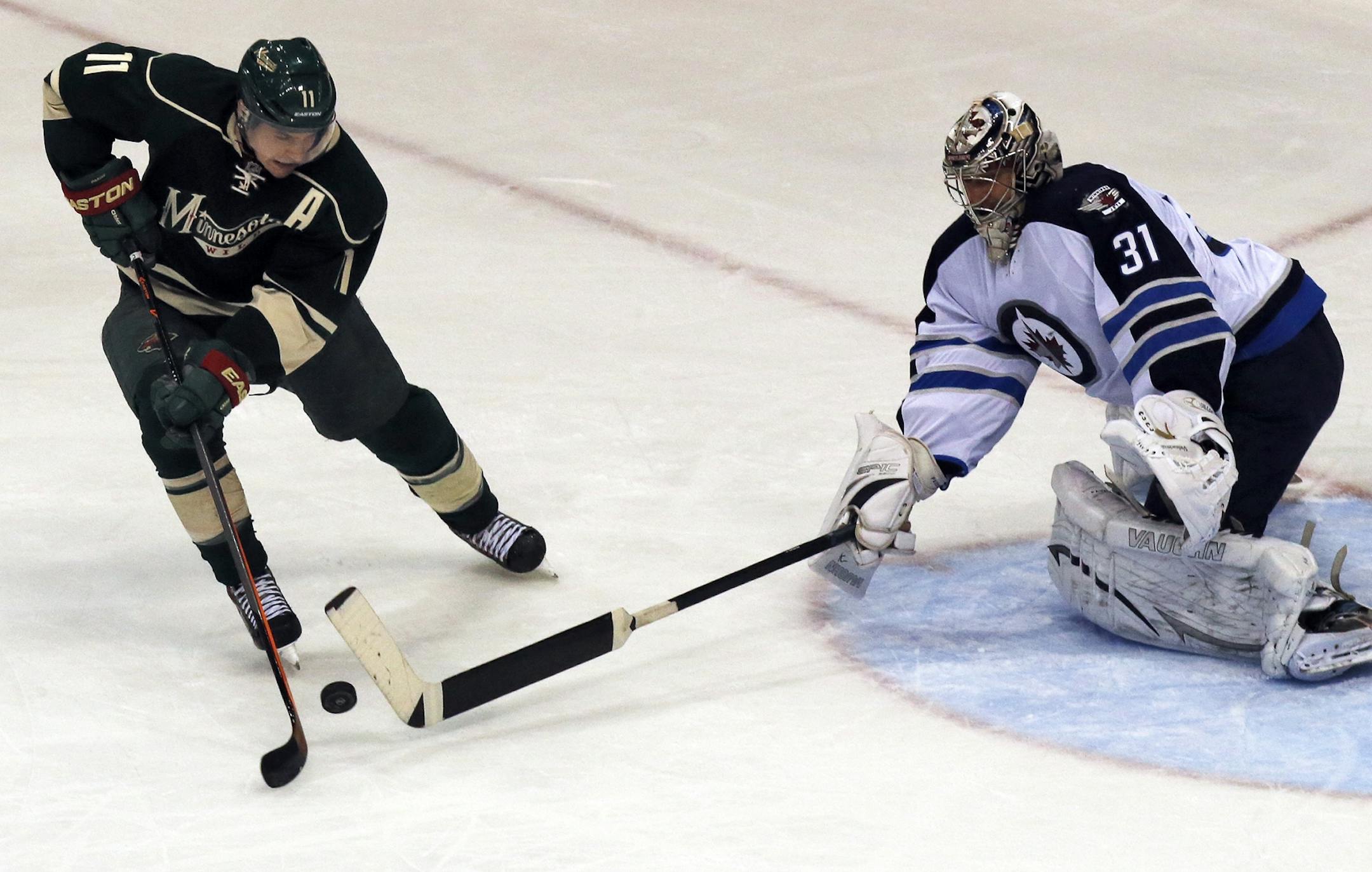 Zach Parise (11) tried to push the puck past Jets goalie Ondrej Pavelec.