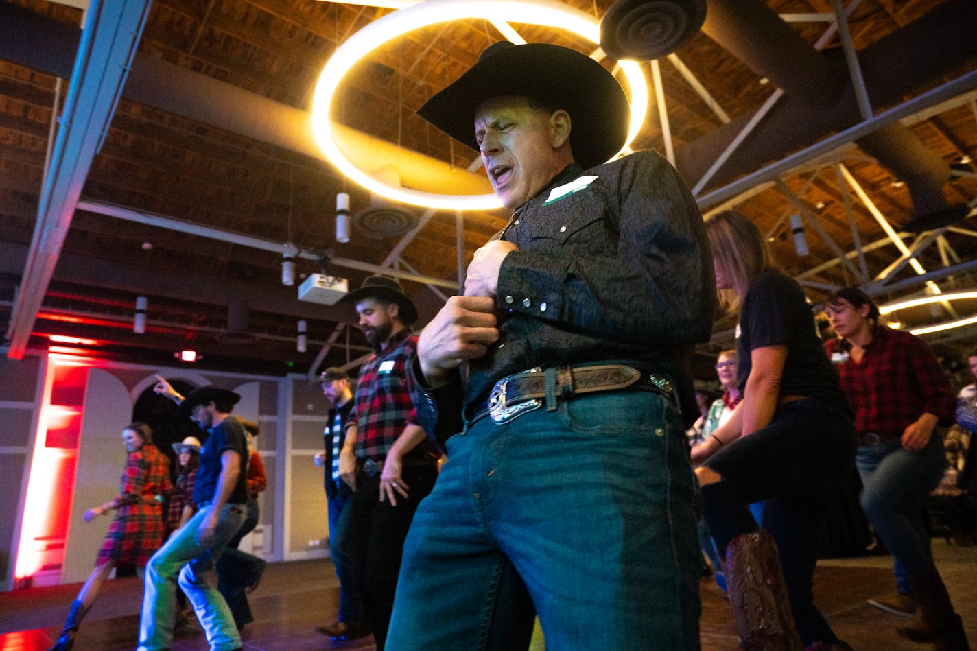 Patrick Smith dances along to Coyote Wild's set at the Ryan Companies' western-themed holiday party in Brooklyn Center, Minn. on Friday, Dec. 1, 2023. In a post-pandemic rise of the company holiday party, over 800 guests were invited to eat, drink and dance the night away. ] Angelina Katsanis • angelina.katsanis@startribune.com