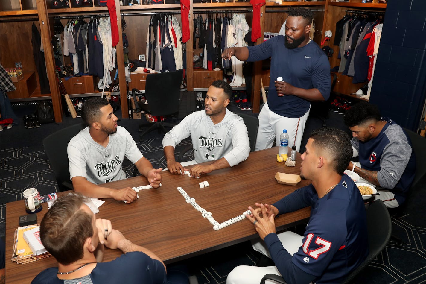 Twins players Logan Morrison, clockwise from bottom left, Eddie Rosario, Gregorio Petit, Fernando Rodney, Fernando Romero and Jose Berrios play dominoes following a game.