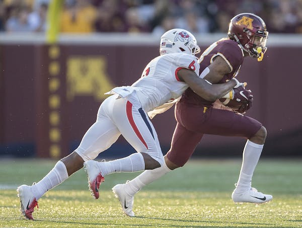 Minnesota's wide receiver Rashod Bateman carried the ball despite pressure from Fresno State's defensive back Anthoula Kelly during the first quarter 