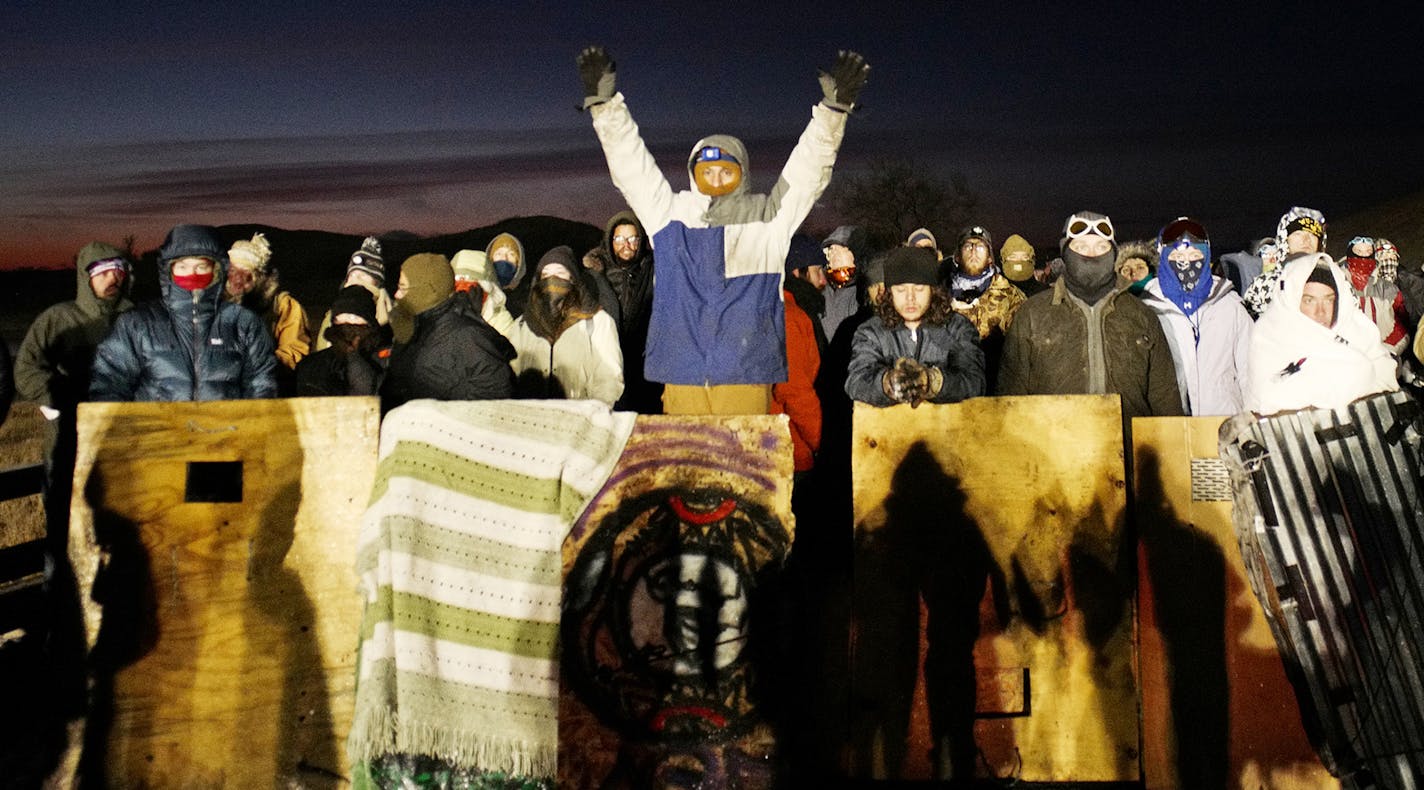 Early in the morning, protestors stood on the off-limits bridge to prevent any advancing of the blockade]The day after an action by protesters to move a truck blocking the bridge leading to the DAPL Pipeline construction near the Standing Rock Reservation led to a police response of tear gas, a water canon, and sound grenades as well as rubber bullets.Richard Tsong-Taatarii/rtsong-taatarii@startribune.com ORG XMIT: MIN1611211755550232