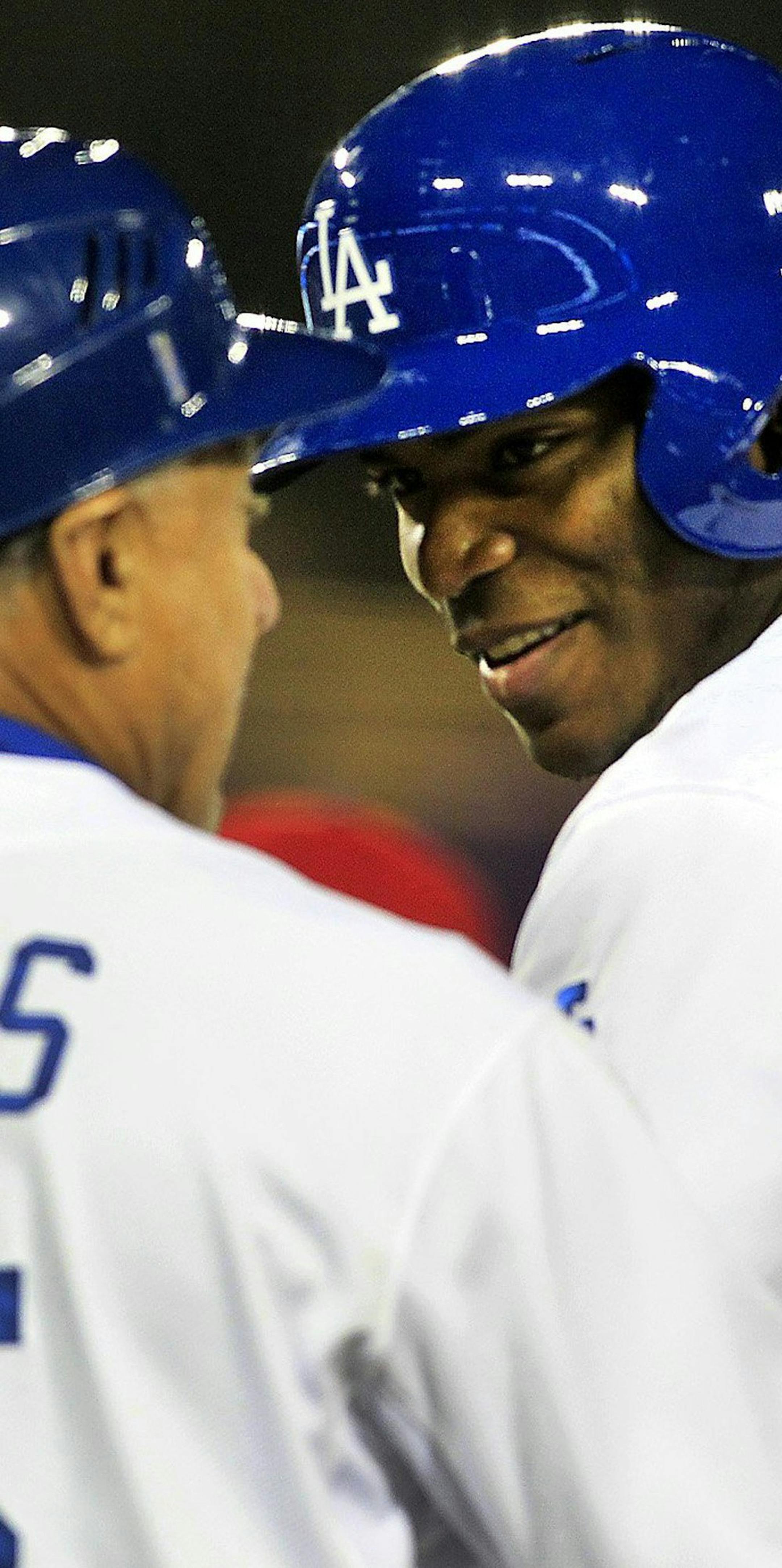 Los Angeles Dodgers first base coach Davey Lopes, left, has a pat on the back for Yasiel Puig, right, after Puig's RBI single in the fifth inning against the Philadelphia Phillies at Dodger Stadium in Los Angeles on Wednesday, April 23, 2014. (Brian van der Brug/Los Angeles Times/MCT) ORG XMIT: 1152109