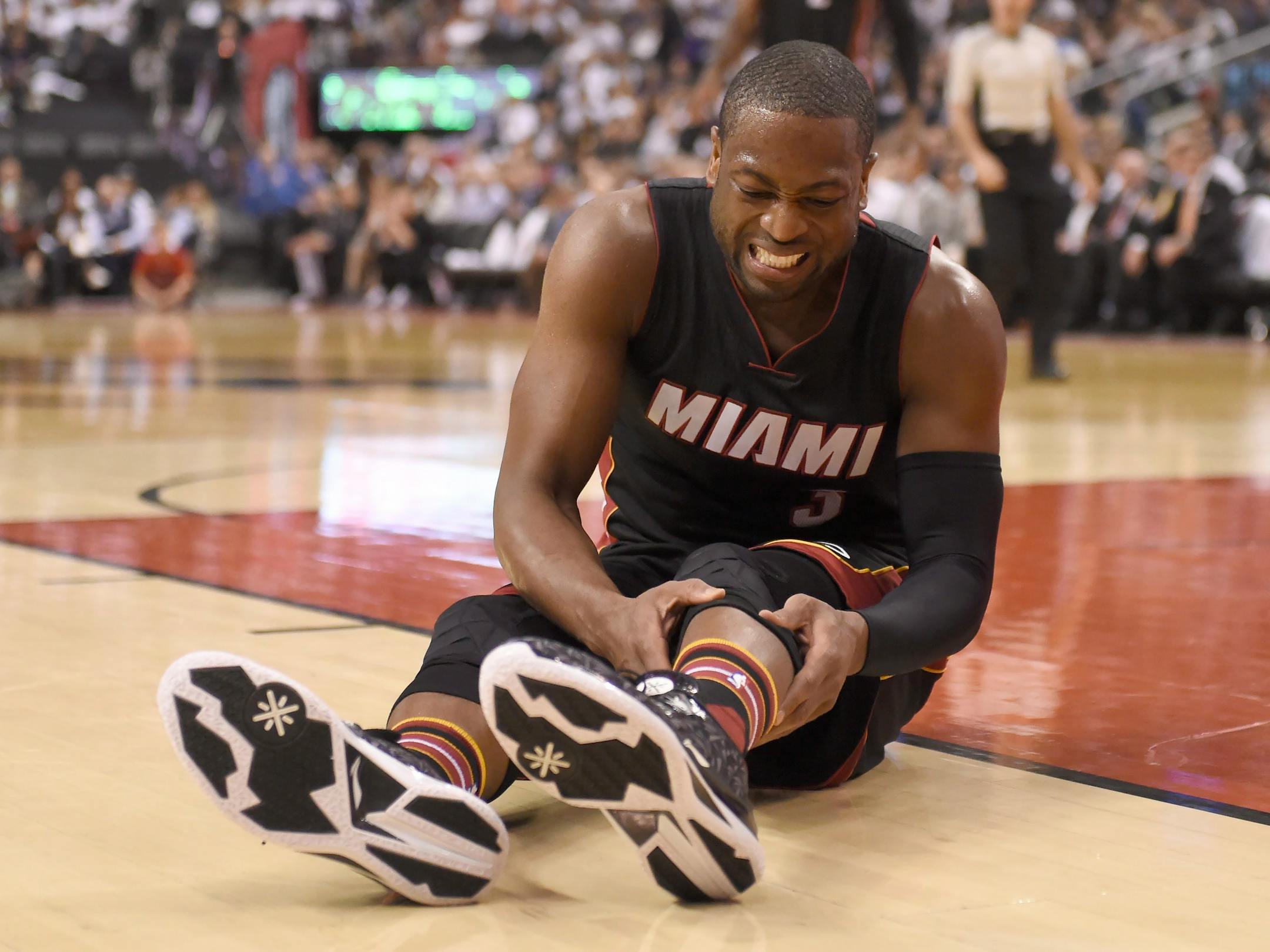 Miami Heat's Dwyane Wade holds his leg after taking a fall during second half NBA playoff basketball action against the Toronto Raptors in Toronto on Thursday, May 5, 2016. (Frank Gunn/The Canadian Press via AP)