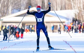 Minneapolis Southwest skier Cooper Camp celebrates as he crosses the finish line of the boys 5k freestyle pursuit race to win the gold medal at the Mi