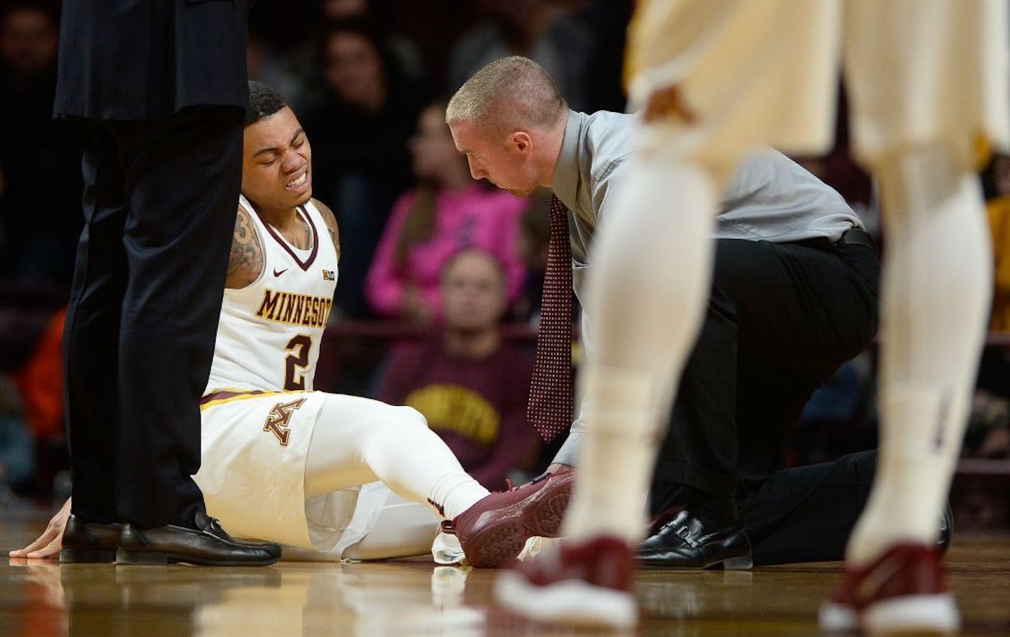 Gophers guard Nate Mason (2) was tended to by a trainer after suffering a leg injury in the second half against Florida Atlantic.