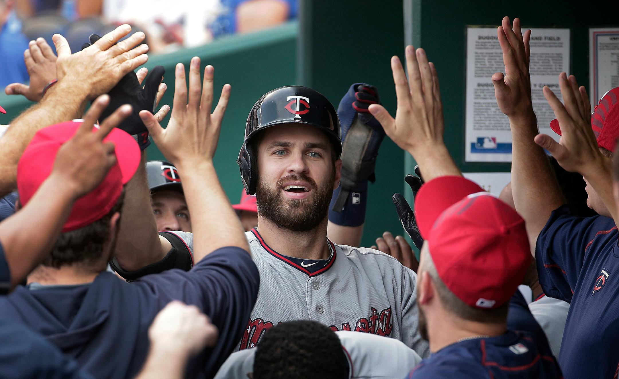 Minnesota Twins' Joe Mauer (7) celebrates in the dugout after his two-run home run during the first inning of a baseball game against the Kansas City Royals on Saturday, July 4, 2015, in Kansas City, Mo. (AP Photo/Charlie Riedel)