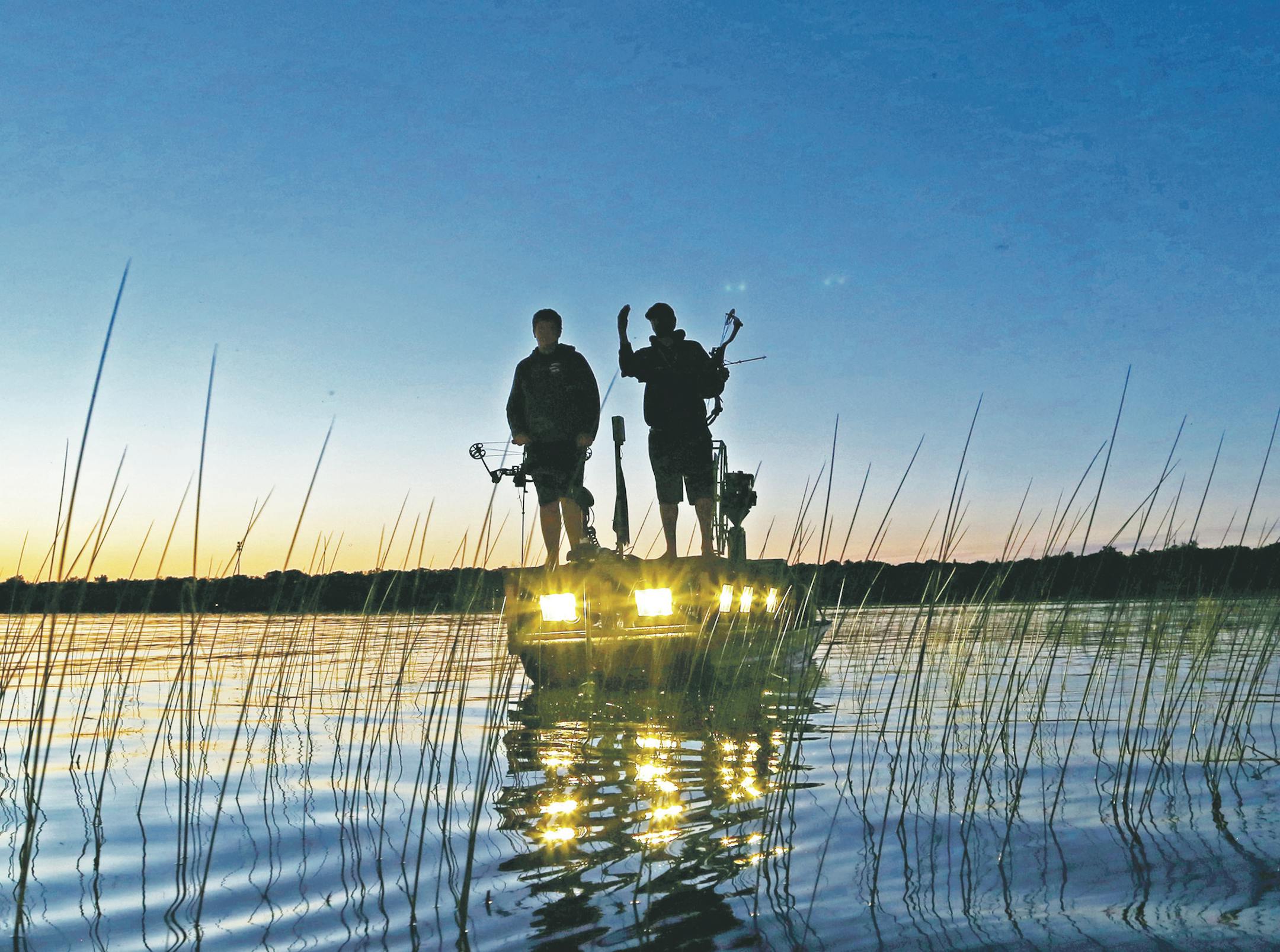 Men of the night: Bowfishermen hunt carp and other "rough'' fish long after the sun goes down, using their boat's bright lights to illuminate carp lurking in the shallows.