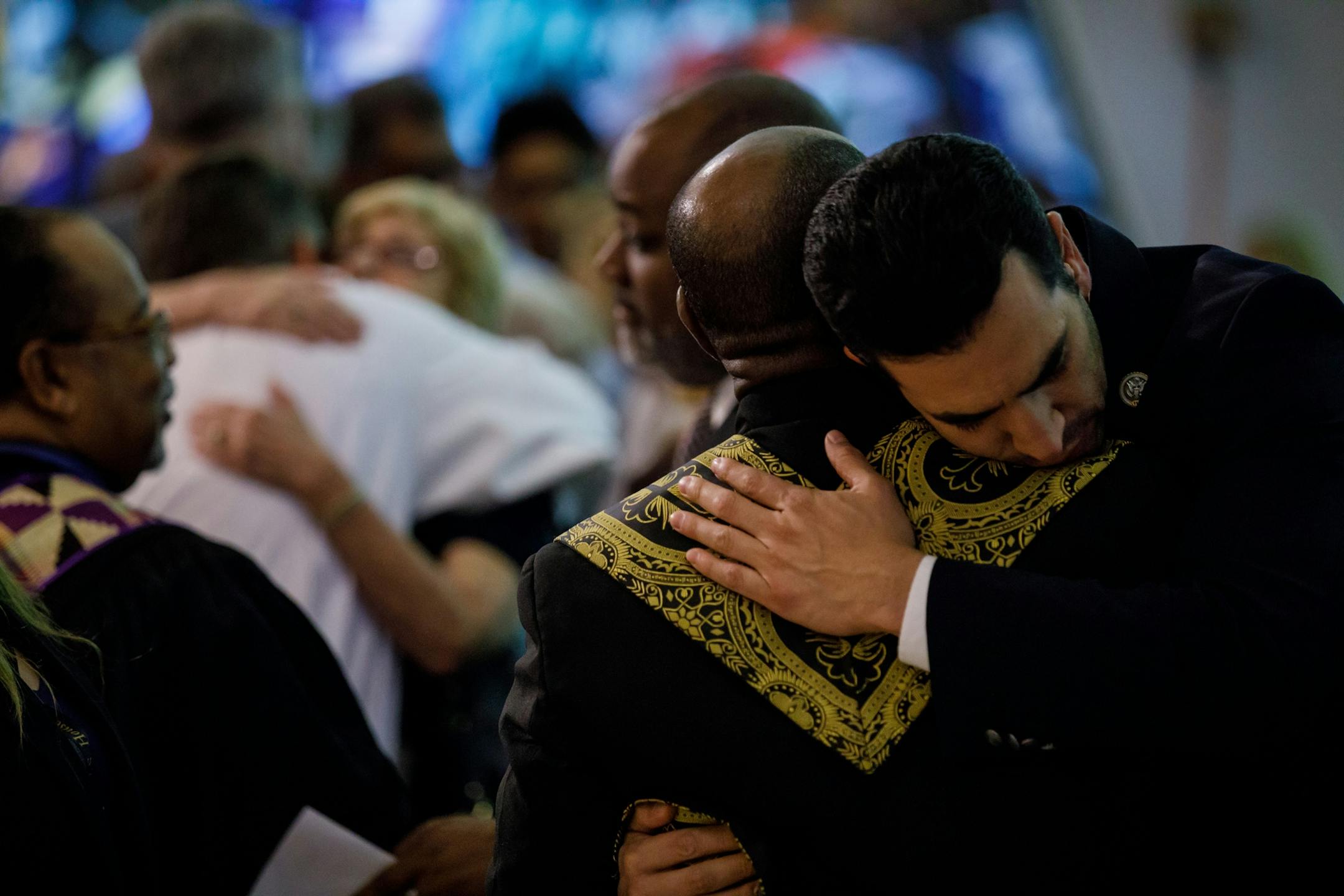 Rep. Ruben Kihuen, D-Nev. hugs clergy as they lead members of the Guardian Angel Cathedral congregation for a prayer event to honor the victims of the mass shooting.