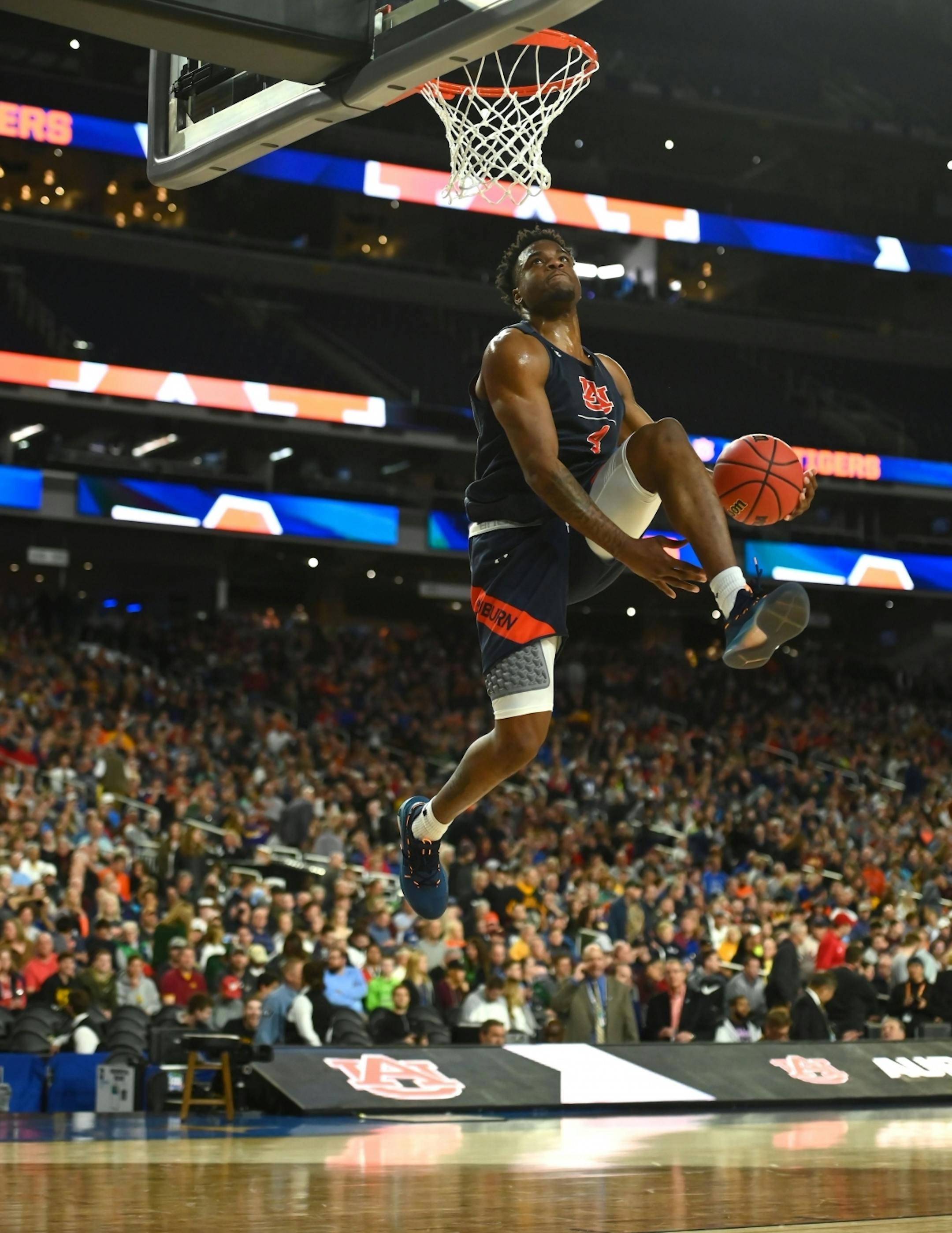 Auburn guard Malik Dunbar (4) dunked during open practice.